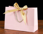 Bowknot Square Paper Bag in pink with a yellow bow and sturdy handle, perfect for eco-friendly gift presentation.
