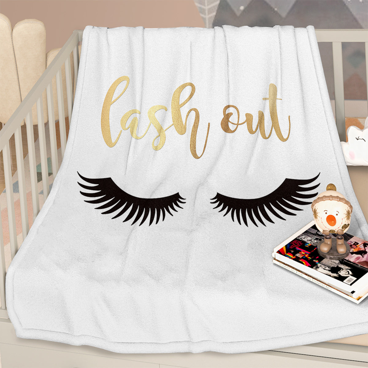 Flannel Velvet Blanket Long Eyelashes displayed on a crib with decorative lashes and word "lash out" in stylish font.