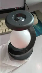 Rotating Moon Desk Lamp with Wireless Charging on a desk, showcasing its sleek design and charging capabilities.